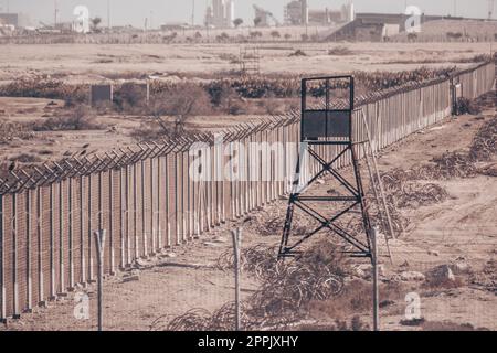 Bordeline rifinito, fili spinato e torre di guardia. Zona militare non passabile Foto Stock