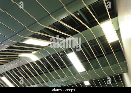 Strutture metalliche sotto il soffitto. Dettagli decorativi del soffitto dell'aeroporto . Travi in calcestruzzo, lustrini in vetro ed elementi in metallo per il design degli interni di edifici pubblici. Architettura astratta all'avanguardia. Foto Stock