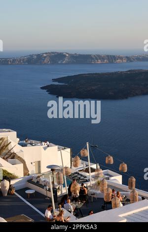 Tavoli sulla terrazza del ristorante con una pittoresca vista sul tramonto a Imerovigli. Santorini Foto Stock