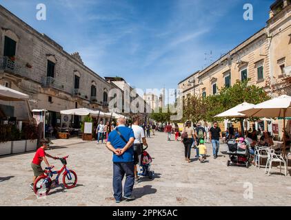 Il turista durante una passeggiata su strada acciottolata nei Sassi di Matera, quartiere storico della città di Matera. Foto Stock