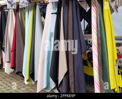 Campioni di tessuti e tessuti in diversi colori presenti in un mercato tedesco dei tessuti Foto Stock