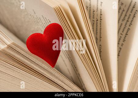 Vista ravvicinata del cuore rosso sulle pagine aperte del libro Foto Stock