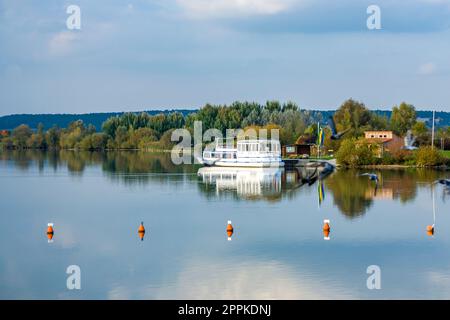 Vista del fiume Altmuehl in Baviera con nave turistica sul molo e riflesso della costa Foto Stock