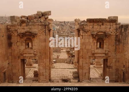 Porta d'ingresso al Tempio di Artemide, Propileo del Santuario di Artemide con la moderna città di Jerash sullo sfondo, Gerasa, Giordania Foto Stock