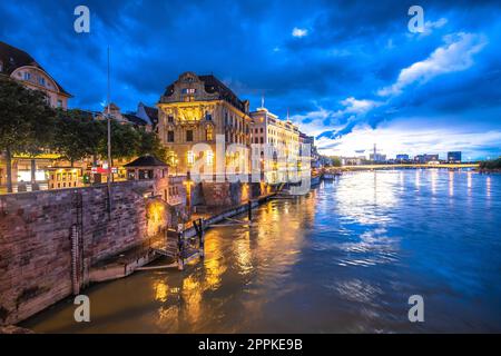 Vista serale sullo storico lungomare di Basilea e sull'architettura del fiume Reno Foto Stock
