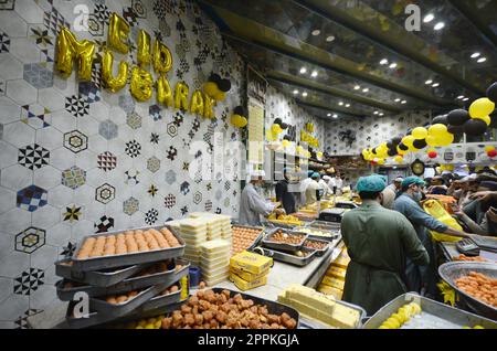 La gente acquista dolci tradizionali in preparazione alle prossime celebrazioni di Eid al-Fitr in un negozio di Peshawar, Pakistan, il 20 aprile 2023. EID al-Fitr segna la fine del mese santo islamico del Ramadan. (Foto di Hussain Ali/Pacific Press/Sipa USA) Foto Stock