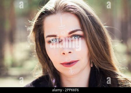 Primo piano donna con i tradizionali segni sciamano sul ritratto del viso Foto Stock