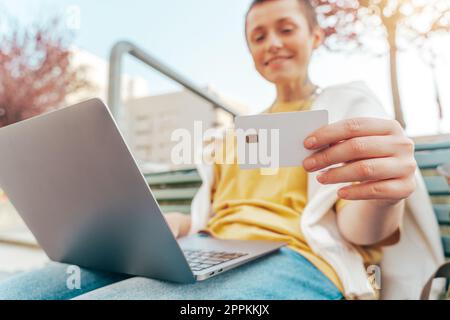 Donna con notebook è pronta a pagare con carta di credito in un negozio online Foto Stock