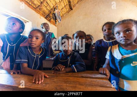 Studenti della scuola malgascia felici in classe. La frequenza scolastica è obbligatoria, ma molti bambini non vanno a scuola. Foto Stock