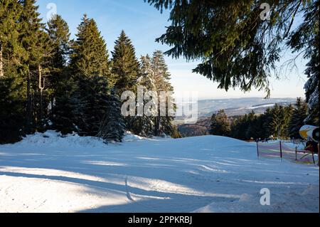 Pista da sci sul Wasserkuppe e cannone da neve sul lato Foto Stock