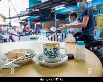 Colazione sull'idilliaco Pulau Ketam, Malesia. Pulau Ketam è vicino a Port Klang ed è stato costruito secoli fa dai pescatori cinesi. Pulau significa isola e Ketam significa granchi. Queste isole hanno milioni di piccoli granchi! L'isola è sede di due prevalentemente chi Foto Stock