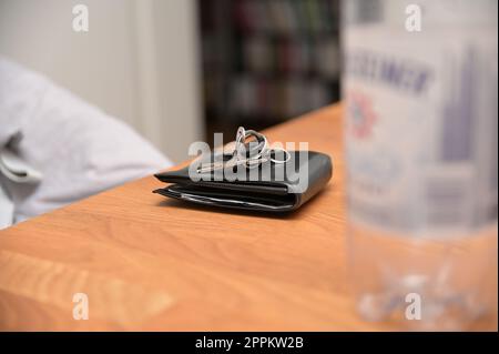 Mazzo di chiavi su un portafoglio in pelle nera Foto Stock