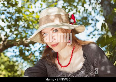 Primo piano donna giocosa con foto ritratto cappello di paglia Foto Stock