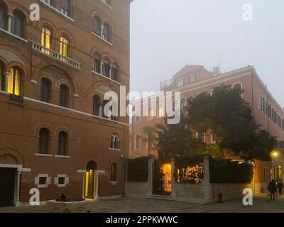 Il lungomare nella nebbia al crepuscolo invernale nella città di Venezia Foto Stock