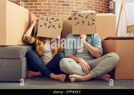Confuso paio di dover spostare e organizzare tutti i pacchetti. Concetto di successo, illusione, modificare , futuro, confusione, questione. Foto Stock