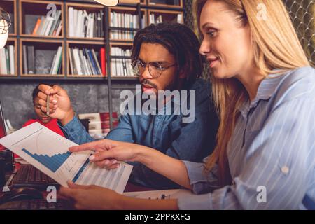 Giovani aziende sorridente l uomo e la donna che lavorano insieme in ufficio analizzando i risultati positivi raggiunti Foto Stock