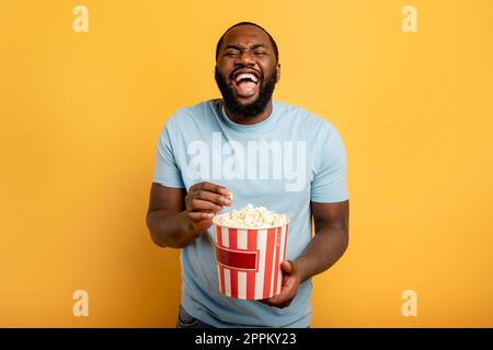 Ragazzo si diverte a guardare un film. Concetto di intrattenimento e TV in streaming. Sfondo rosso Foto Stock