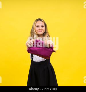 Ragazza di scuola felice con matite colorate e una custodia a matita in mano Foto Stock