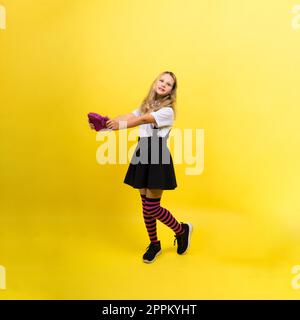 Ragazza di scuola felice con matite colorate e una custodia a matita in mano Foto Stock