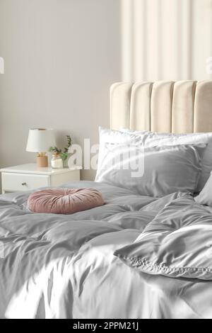 Letto con eleganti lenzuola di seta in camera Foto stock - Alamy