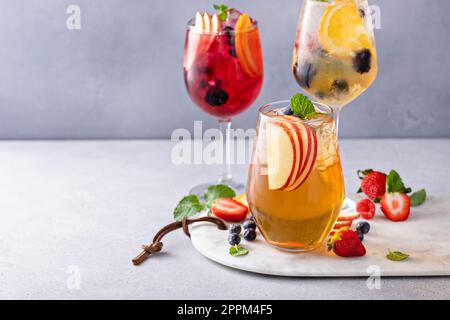 Rinfrescanti sangria estiva con vino bianco e rosso, mele e arance, varietà di bevande Foto Stock