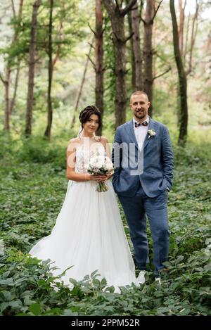 passeggiata nuziale della sposa e sposo nella foresta decidua in estate Foto Stock