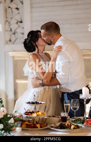 gli sposi novelli tagliano e assaggiano la torta nuziale Foto Stock