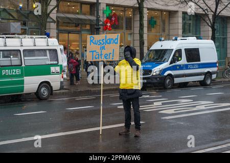 BERLINO - 25 FEBBRAIO 2023: Attivista ucraino con un poster in tedesco - 'la Russia è un criminale' di fronte all'ambasciata russa su Unter der Linden. Foto Stock