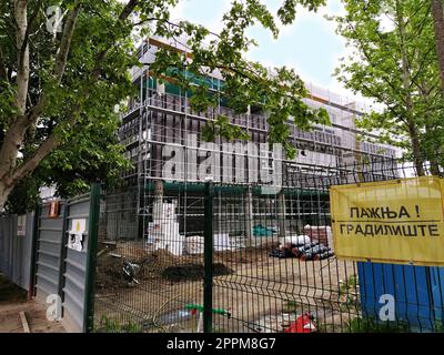 Sremska Mitrovica, Serbia. 30 maggio 2020. Costruzione di una nuova scuola a Sremska Mitrovica. L'edificio è nelle fasi finali della costruzione. Recinzione metallica. La scritta Caution Construction. Foto Stock