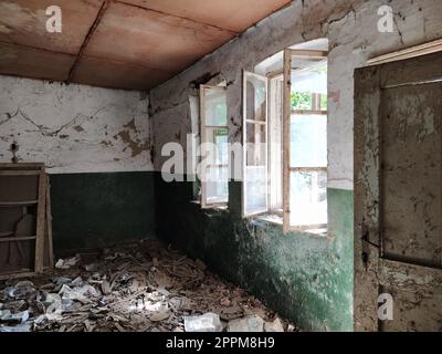 Finestre spaventose. In una casa abbandonata. Vista delle finestre rotte senza tenda. Scena grunge. La luce splende attraverso vecchie strutture in legno con vetri rotti. Il concetto di abbandono e inutilità. Foto Stock