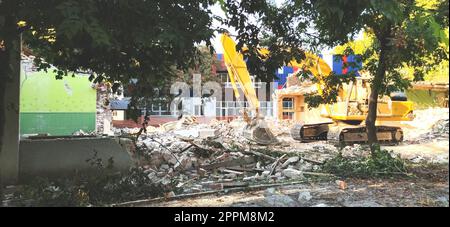Sremska Mitrovica, Serbia, 13 agosto 2020. Smantellamento e demolizione della vecchia scuola che prende il nome da Jovan Popovic. Pezzi di cemento e armatura sono appesi. I bulldozer stanno abbattendo i muri. Foto Stock