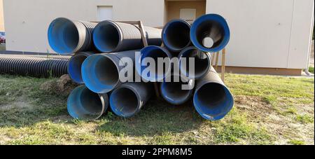 Sremska Mitrovica, Serbia, 23 agosto 2020. Tubi corrugati in metallo, blu all'interno. I tubi idraulici o di riscaldamento si trovano sul terreno accanto a un edificio residenziale. Metallo corrugato Foto Stock