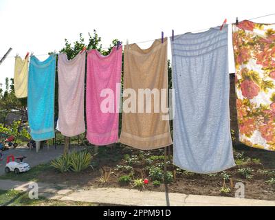 Sremska Mitrovica, Serbia 10 luglio 2020, asciugamani e vestiti asciutti su una corda. La casalinga si preoccupa. Il panno bagnato è appeso ai clothespins per un'ulteriore asciugatura. un gran bucato Foto Stock