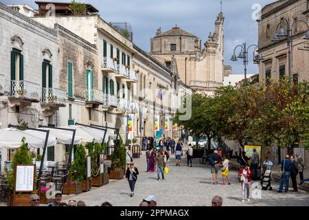 Il turista durante una passeggiata su strada acciottolata nei Sassi di Matera, quartiere storico della città di Matera. Foto Stock