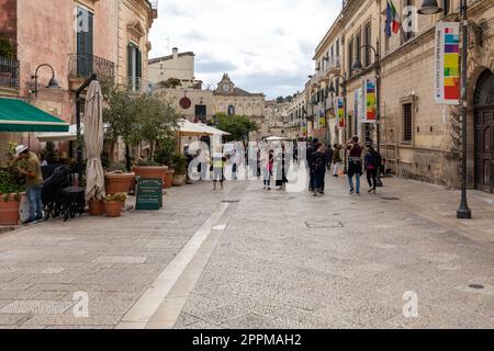 Il turista durante una passeggiata su strada acciottolata nei Sassi di Matera, quartiere storico della città di Matera. Foto Stock