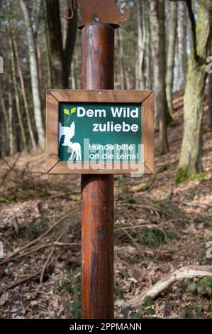 Cartello tedesco in un parco faunistico per il bene della natura selvaggia, si prega di tenere i cani su un guinzaglio verticale Foto Stock