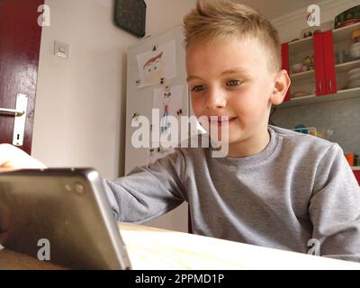 Sremska Mitrovica, Serbia, 20 maggio 2020 ragazzo biondo con portatile. Il bambino guarda il monitor. L'emozione della gioia Foto Stock