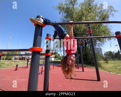 Sremska Mitrovica, Serbia. 6 giugno 2020. Infradito, sollevamento pesi e pesi, esercizi di forza. Due adolescenti vanno a fare sport su simulatori, bambini su un campo sportivo Foto Stock