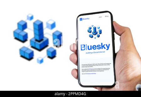 Mano che regge un telefono con l'app mobile Bluesky sullo schermo Foto Stock