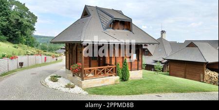 3 luglio 2020. Vrdnik, Serbia. Bungalow e pensioni in stile etnico Levereno per i vacanzieri. Architettura di montagna di log Balkan. Hotel o hotel, prati ben tenuti Foto Stock