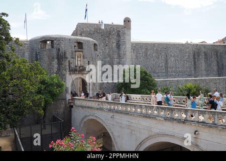 Pile Gate Dubrovnik Croazia 14 agosto 2022 persone uomini e donne camminano lungo il ponte di pietra fino alla porta della città Vecchia. Folla di turisti. Ingresso affollato. L'ingresso principale della città Vecchia, l'affollata porta pile Foto Stock