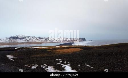 Vista dal faro di Dyrholaey in Islanda che si affaccia sulla spiaggia di sabbia nera. Foto Stock
