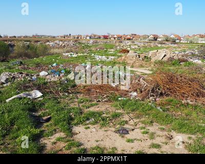 Sremska Mitrovica, Chalma, Serbia, 5 aprile 2021discarica nei pressi del villaggio. Caotica discarica non ufficiale. Plastica, sacchetti, carta, vetro, rifiuti biologici. Erba verde accanto alla sporcizia. Catastrofe ecologica. Foto Stock