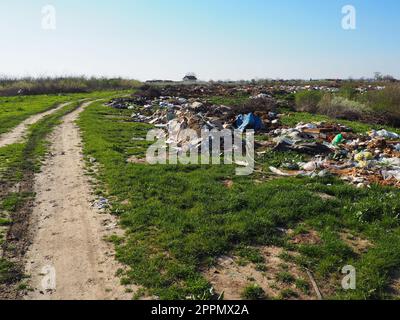 Sremska Mitrovica, Chalma, Serbia, 5 aprile 2021discarica nei pressi del villaggio. Caotica discarica non ufficiale. Plastica, sacchetti, carta, vetro, rifiuti biologici. Erba verde accanto alla sporcizia. Catastrofe ecologica. Foto Stock