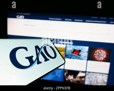 Cellulare con il logo del governo degli Stati Uniti Accountability Office (GAO) sullo schermo di fronte al sito web. Messa a fuoco al centro a destra del display del telefono. Foto Stock