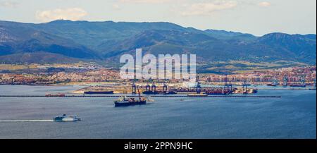 Vista panoramica del porto industriale di Algésiras nel sud della Spagna - Gru giganti che caricano container su navi da carico nel Mediterraneo Foto Stock