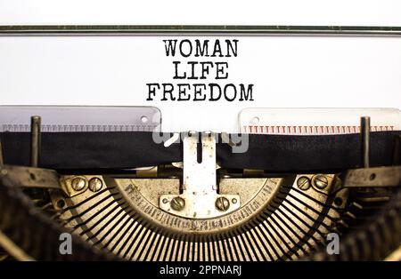 Donna vita libertà simbolo. Concetto di parole Donna vita libertà digitato su una vecchia macchina da scrivere retrò su uno sfondo bello bianco carta. Problema sociale donna Foto Stock