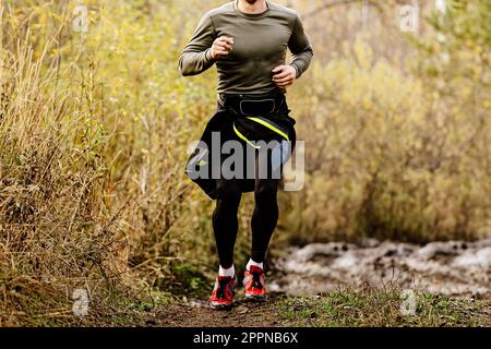 corridore maschile in corsa sulla maratona autunnale, corsa di corsa di fondo Foto Stock