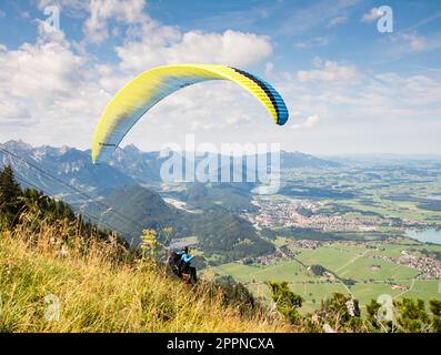 SCHWANGAU, GERMANIA - 23 AGOSTO: Parapendio sconosciuto sul monte Tegelberg a Schwangau, Germania il 23 agosto 2015. Tegelberg è una delle più popolari Foto Stock