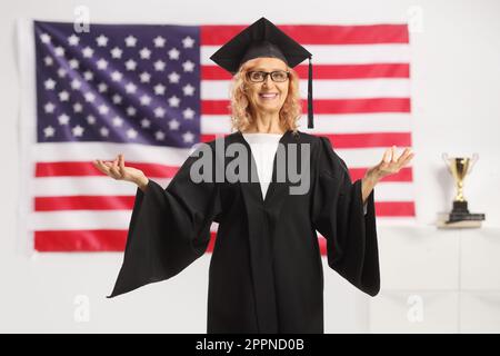 Professoressa universitaria in piedi di fronte a una bandiera degli Stati Uniti e gesturing con le mani Foto Stock